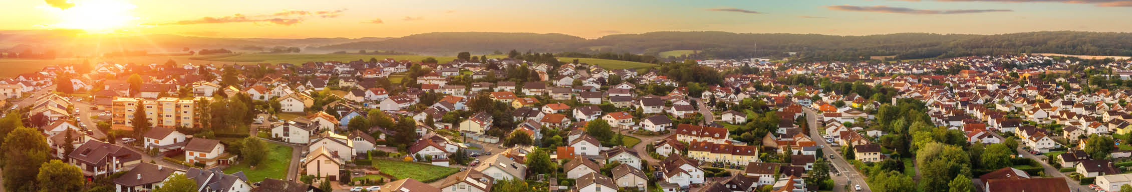 Aerial panorama of a small town at sunrise, with magnificent colorful sky and warm light